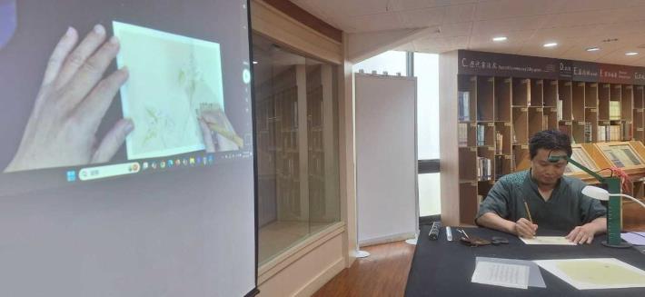 劉鴻旗講師//端身正坐，現場以極細的筆鋒書寫出僅0.2公分高的小楷字