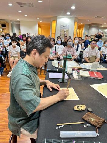 劉鴻旗講師//端身正坐，現場以極細的筆鋒書寫出僅0.2公分高的小楷字