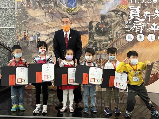 財團法人滄洲文教基金會董事長陳治明頒發寫生比賽幼兒園組得獎獎狀